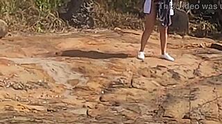 Young beauty watched having public sex on beach rocks