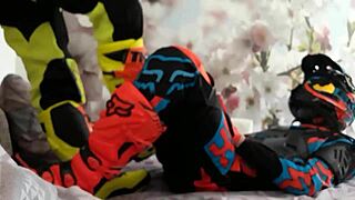 Motocross gay in biker costumes, boots treading on the action.