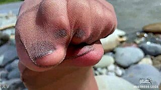 Goddess teases with tan nylons and cute soles by the river