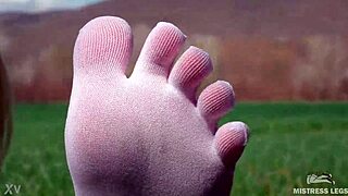 Adoring her cute feet in white socks on spring grass with jeans.