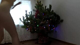 bitch with small tits dances around christmas tree showing ass and pussy