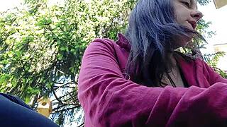 Nicoletta lights up a smoke in a public garden and boldly flashes her large tits by exposing them from her shirt