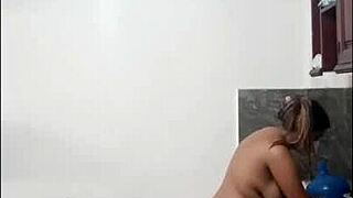 cute tall woman cooks naked in kitchen