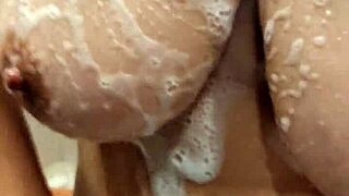 Milf gets naked in the shower, revealing big tits while bathing sensually in private moment.