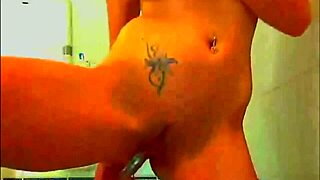 tattooed model enjoys playing with her glass dildo in the bathroom