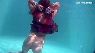 Redhead babe Nikita Vodorezova strips naked quickly in underwater pool scene