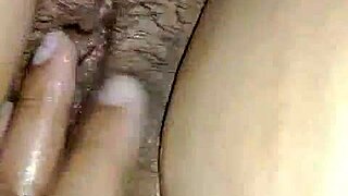 Boyfriend passionately fingers oiled hairy pussy of hot masturbating girl in intimate moment.