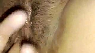 Boyfriend passionately fingers oiled hairy pussy of hot masturbating girl in intimate moment.