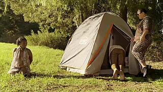 Tall ebony goddess dominates beach slaves in latex boots