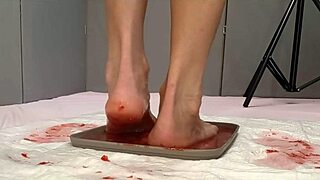Beautiful feet pee on and trample fresh strawberries