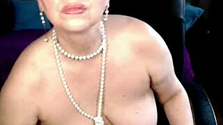 Charming mature woman self-fists her pussy up close with a smile