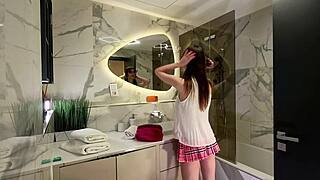 Hey, peep this long-legged nerdy college cutie rocking a tiny pink skirt and thong panties, teasing in the bathroom mirror! 😏👅🩲