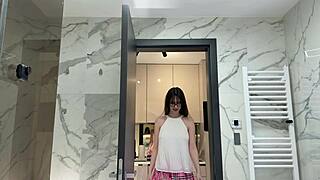 Hey, peep this long-legged nerdy college cutie rocking a tiny pink skirt and thong panties, teasing in the bathroom mirror! 😏👅🩲